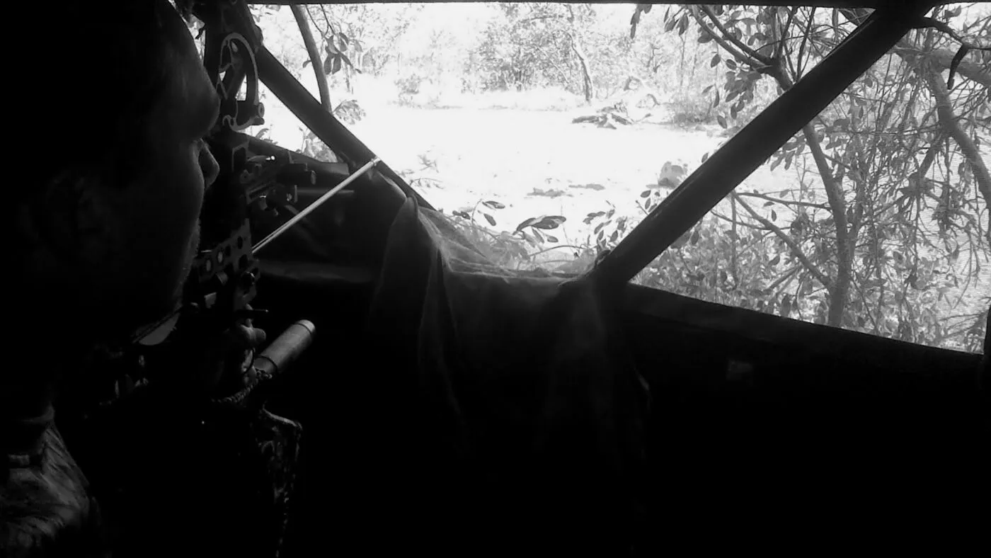 A bowhunter at full draw inside a ground blind